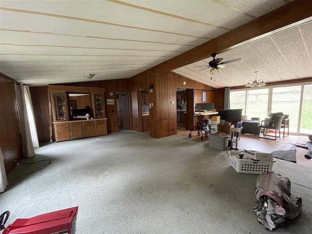 living area featuring a ceiling fan, carpet floors, wooden walls, and vaulted ceiling with beams