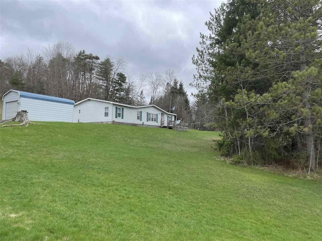 view of yard with a detached garage and an outdoor structure