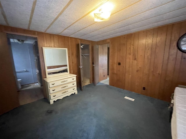 unfurnished bedroom with wooden walls and carpet