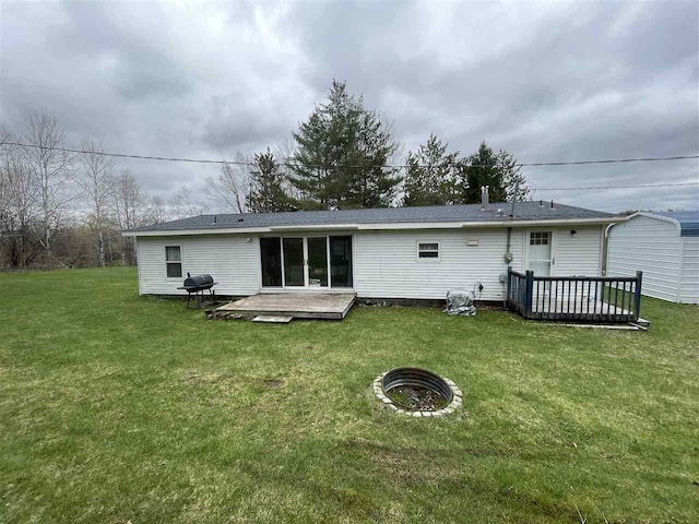 rear view of property with a yard and a deck