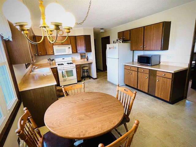 1368 S M-88, Bellaire, MI 49615 - kitchen featuring a sink, white appliances, a textured ceiling, light countertops, and a notable chandelier