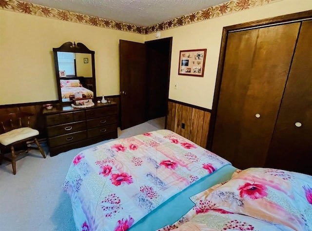 1368 S M-88, Bellaire, MI 49615 - bedroom featuring a textured ceiling, carpet, a closet, and a wainscoted wall