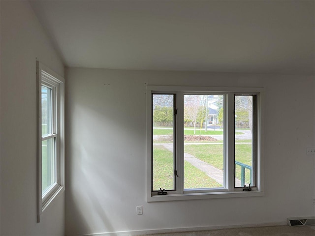 empty room featuring plenty of natural light, baseboards, and carpet