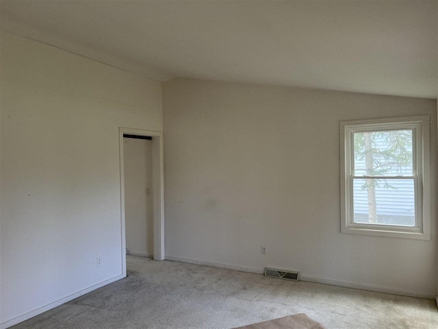 unfurnished room with vaulted ceiling, carpet floors, and baseboards