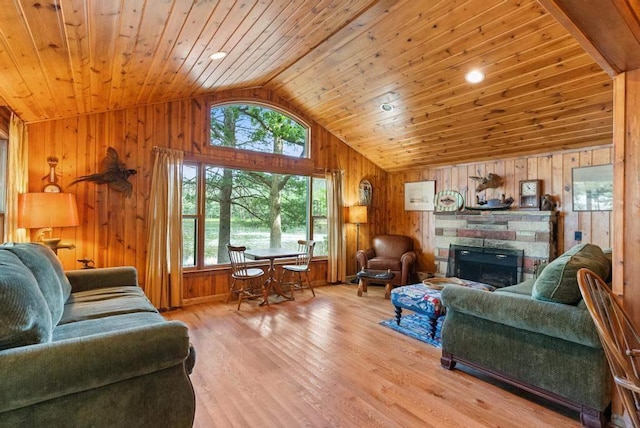 14786 Nuenfelt Rd, Johannesburg, MI 49756 - living area featuring vaulted ceiling, wooden ceiling, wood walls, wood finished floors, and a stone fireplace