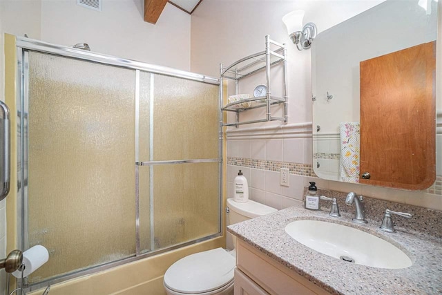 3414 Reycraft Rd, Boyne City, MI 49712 - bathroom featuring tile walls, toilet, shower / bath combination with glass door, and vanity