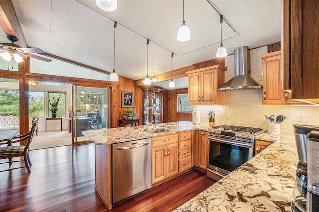 3414 Reycraft Rd, Boyne City, MI 49712 - kitchen featuring stainless steel appliances, wall chimney range hood, a sink, dark wood finished floors, and light stone countertops