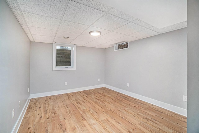 110 Hillcrest, East Jordan, MI 49727 - below grade area with wood finished floors, baseboards, and a drop ceiling