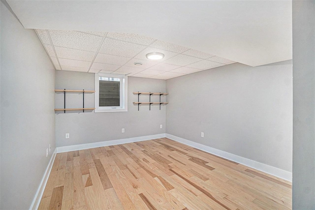 110 Hillcrest, East Jordan, MI 49727 - below grade area featuring a drop ceiling, light wood-style floors, and baseboards