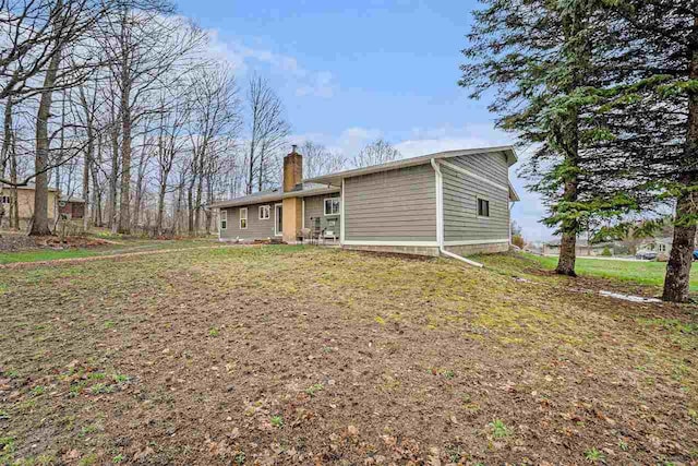 110 Hillcrest, East Jordan, MI 49727 - back of property with a chimney and a yard