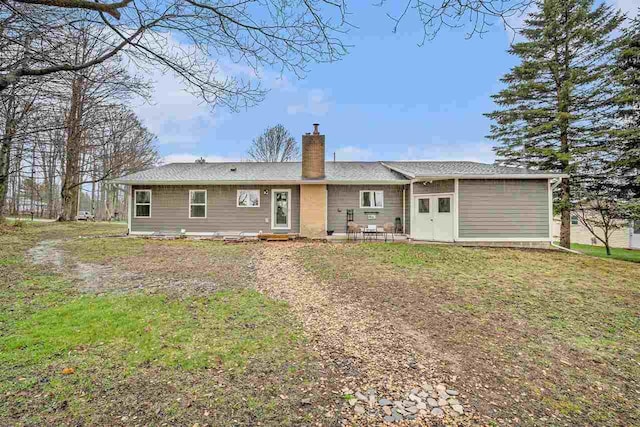 110 Hillcrest, East Jordan, MI 49727 - rear view of property with a chimney and a yard