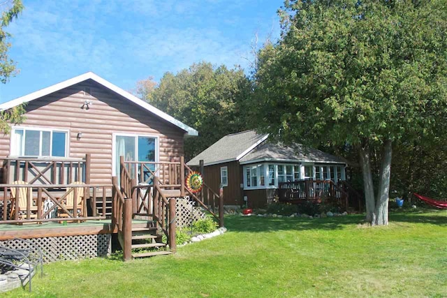 back of house featuring a deck, a yard, and log veneer siding