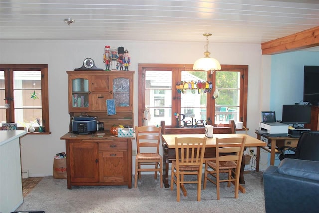 dining space with french doors and light carpet
