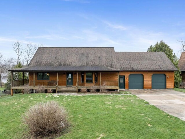 8120 Susan Shore Dr, Charlevoix, MI 49720 - view of front facade featuring a garage, a porch, concrete driveway, and a front lawn