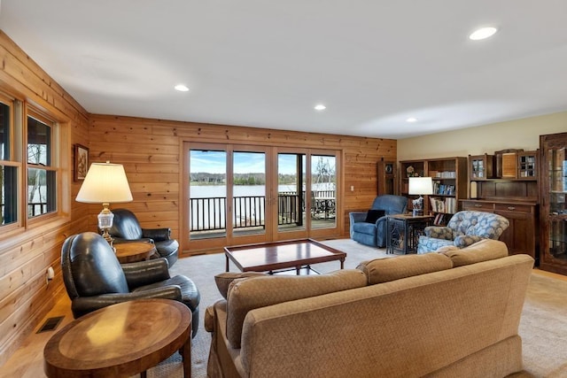 8120 Susan Shore Dr, Charlevoix, MI 49720 - living room with recessed lighting, light carpet, wooden walls, and a water view