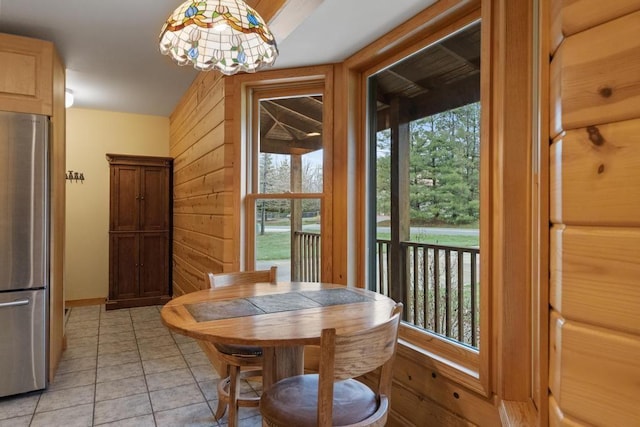 8120 Susan Shore Dr, Charlevoix, MI 49720 - dining room with healthy amount of natural light, a chandelier, light tile patterned flooring, and wood walls