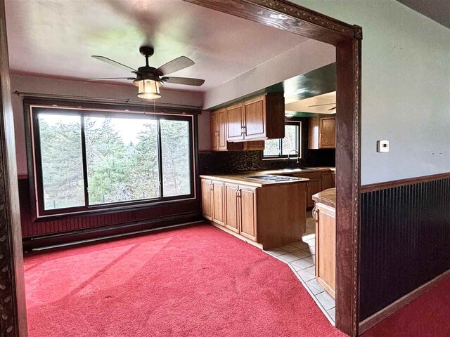 kitchen featuring plenty of natural light, ceiling fan, light colored carpet, and light tile patterned floors