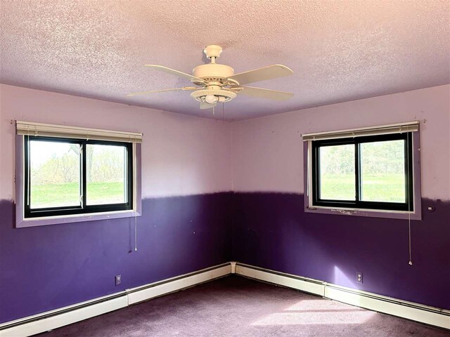 unfurnished room with carpet, plenty of natural light, a textured ceiling, a ceiling fan, and baseboards