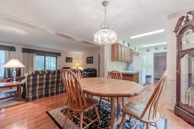 dining area with a chandelier and light wood-style floors