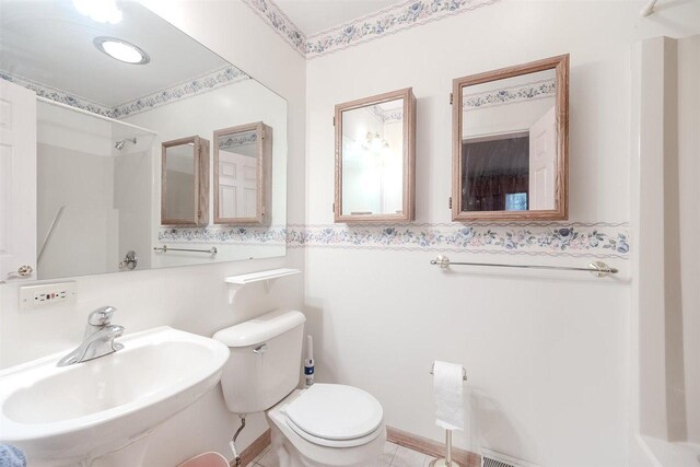 bathroom with a sink, toilet, a shower, and tile patterned floors