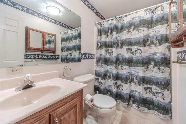 full bathroom with toilet, vanity, curtained shower, and tile patterned floors