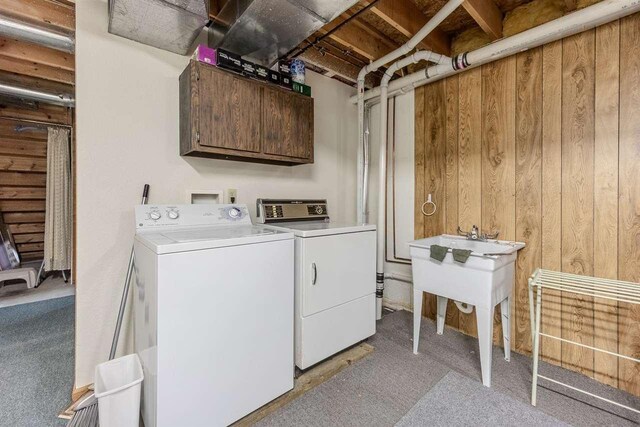 laundry area with cabinet space, independent washer and dryer, and light carpet