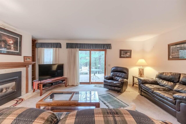 living room featuring light carpet and a tiled fireplace
