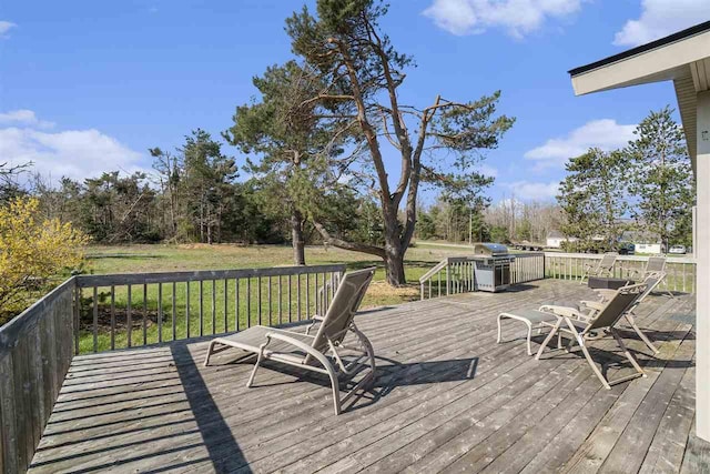 wooden deck featuring grilling area and a lawn