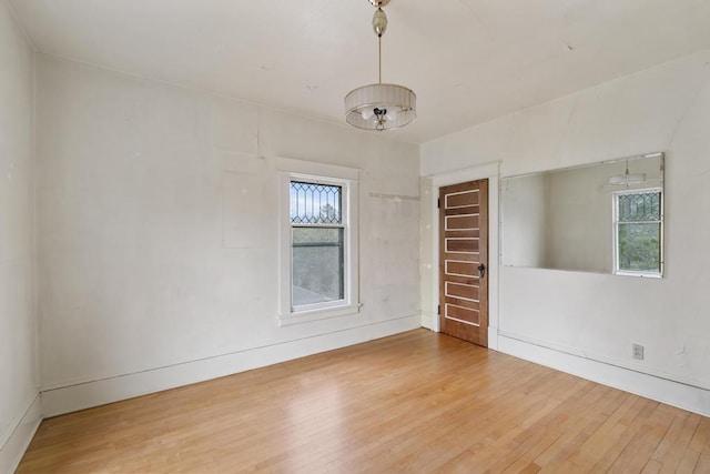 619 Kalamazoo Ave, Petoskey, MI 49770 - unfurnished room featuring wood finished floors, healthy amount of natural light, and baseboards