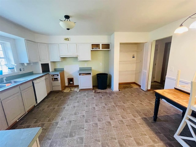 204 E Forest Home Ave, Bellaire, MI 49615 - kitchen with dishwasher, a sink, and white cabinetry