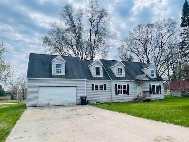 204 E Forest Home Ave, Bellaire, MI 49615 - cape cod house with a garage, concrete driveway, and a front lawn