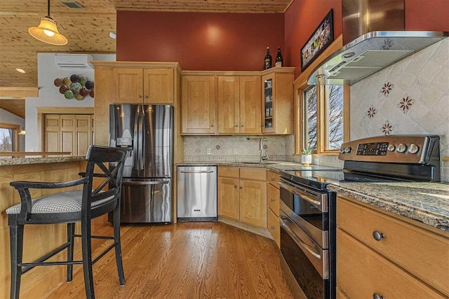 4133 Shadynook Rd, Central Lake, MI 49622 - kitchen featuring stainless steel appliances, light wood-type flooring, a sink, light stone countertops, and wall chimney exhaust hood