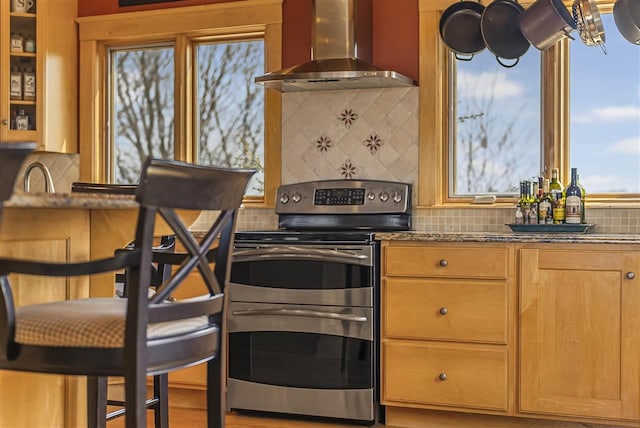 4133 Shadynook Rd, Central Lake, MI 49622 - kitchen with wall chimney range hood, range with two ovens, decorative backsplash, and dark stone countertops