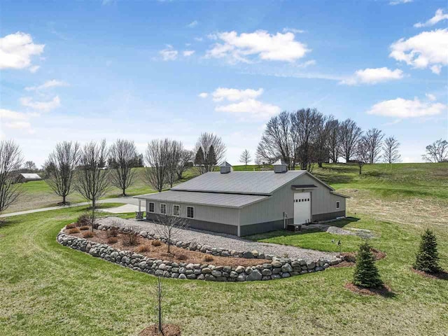 4133 Shadynook Rd, Central Lake, MI 49622 - view of side of home featuring a lawn, a garage, an outdoor structure, and metal roof
