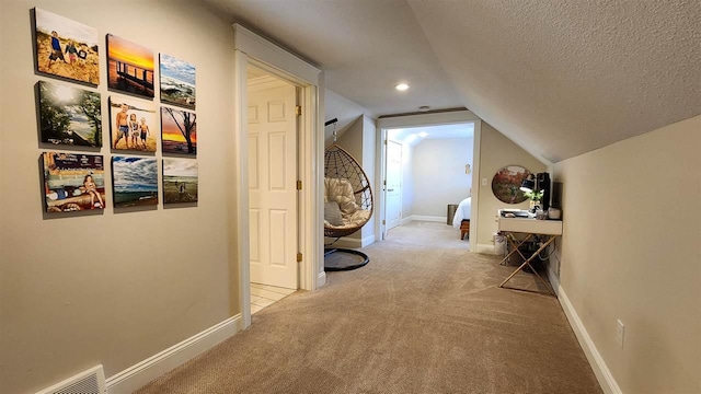 hallway with carpet flooring, vaulted ceiling, baseboards, a textured ceiling, and recessed lighting