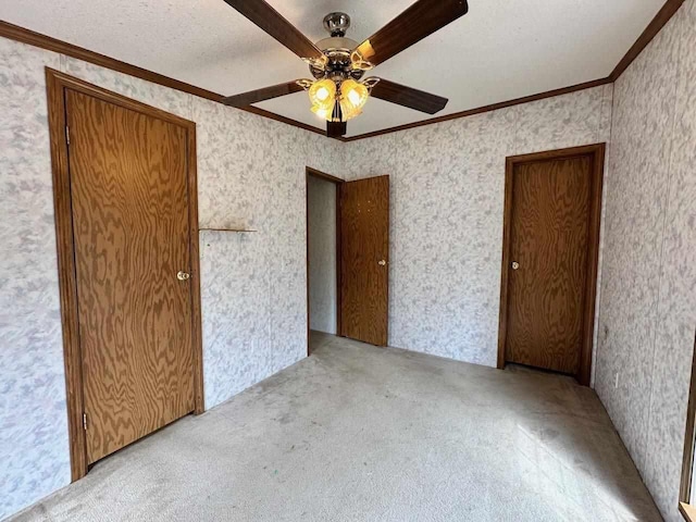4049 Musser Rd, Mancelona, MI 49659 - unfurnished bedroom featuring crown molding, carpet flooring, wallpapered walls, and a ceiling fan