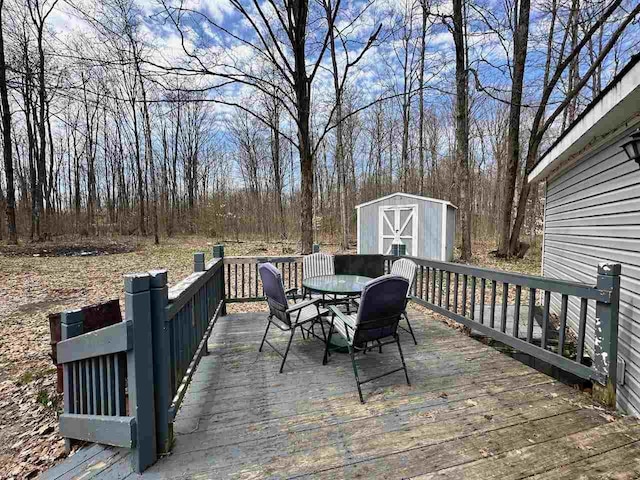 4049 Musser Rd, Mancelona, MI 49659 - wooden deck with outdoor dining area, a shed, and an outdoor structure