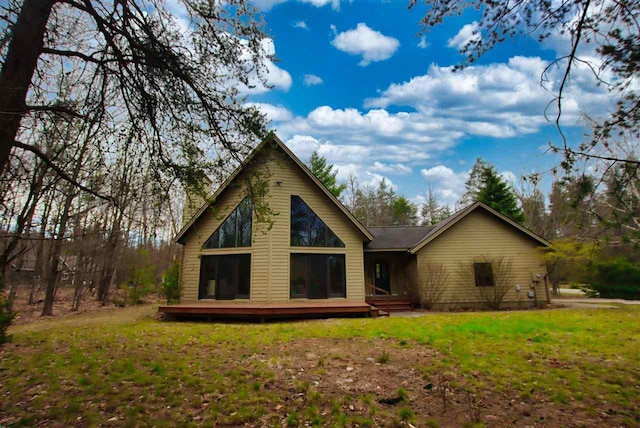 3330 Commodore Dr, East Jordan, MI 49727 - rear view of house featuring a deck and a lawn