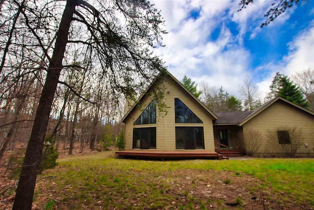 3330 Commodore Dr, East Jordan, MI 49727 - back of house featuring a deck and a lawn