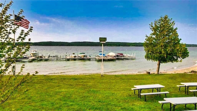 3330 Commodore Dr, East Jordan, MI 49727 - dock area featuring a water view and a lawn