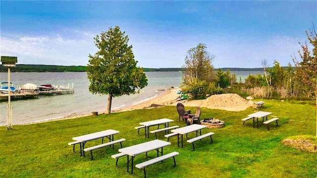 3330 Commodore Dr, East Jordan, MI 49727 - view of property's community with an outdoor fire pit, a water view, a yard, and a dock