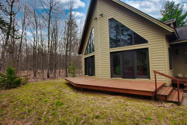 3330 Commodore Dr, East Jordan, MI 49727 - rear view of house with a wooden deck and a yard