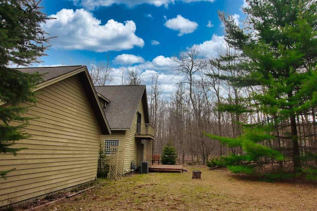 3330 Commodore Dr, East Jordan, MI 49727 - view of property exterior with a balcony and roof with shingles