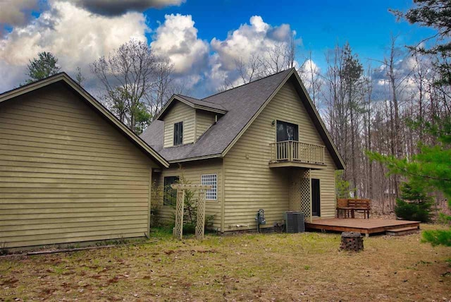 3330 Commodore Dr, East Jordan, MI 49727 - back of property with a balcony, central AC, a wooden deck, and a lawn