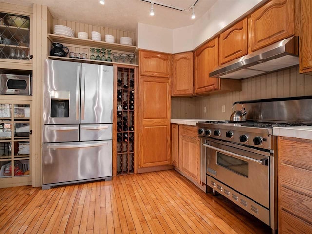 101 S Addis Rd, Boyne City, MI 49712 - kitchen with appliances with stainless steel finishes, under cabinet range hood, brown cabinetry, and light countertops