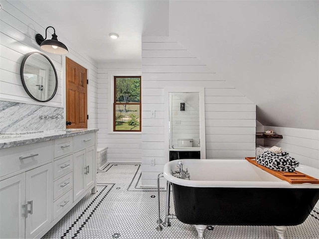 101 S Addis Rd, Boyne City, MI 49712 - bathroom featuring wood walls, vanity, a freestanding tub, and lofted ceiling
