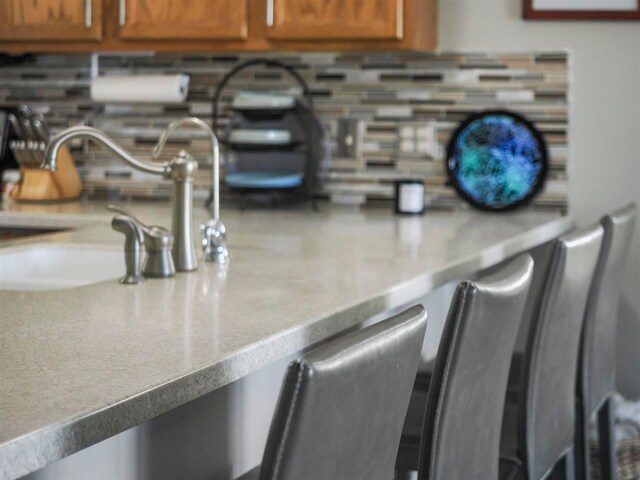 1564 Emerald Ct Unit 85, Petoskey, MI 49770 - kitchen view of backsplash, brown cabinetry, light countertops, and a sink