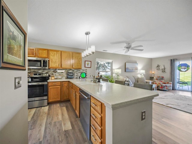 1564 Emerald Ct Unit 85, Petoskey, MI 49770 - kitchen featuring appliances with stainless steel finishes, a sink, light wood-type flooring, and a peninsula