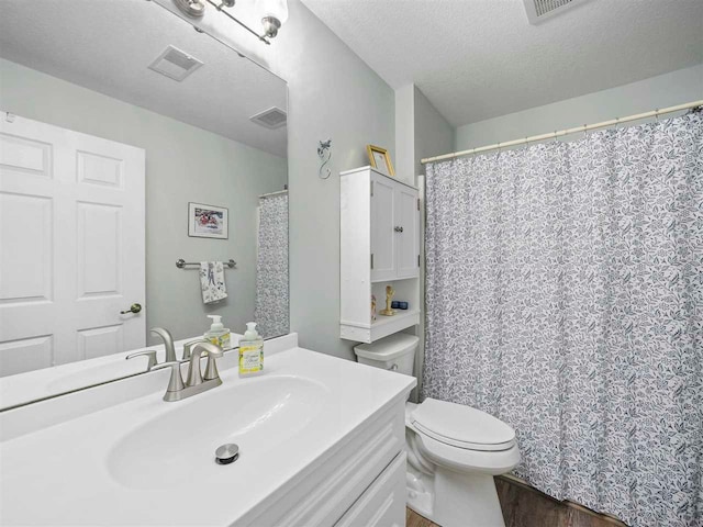 1564 Emerald Ct Unit 85, Petoskey, MI 49770 - bathroom with toilet, wood finished floors, vanity, and a textured ceiling