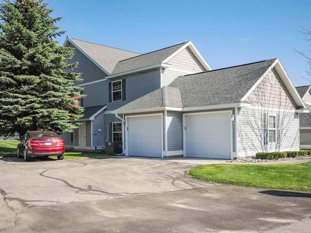 1564 Emerald Ct Unit 85, Petoskey, MI 49770 - view of home's exterior featuring a garage, a shingled roof, and asphalt driveway